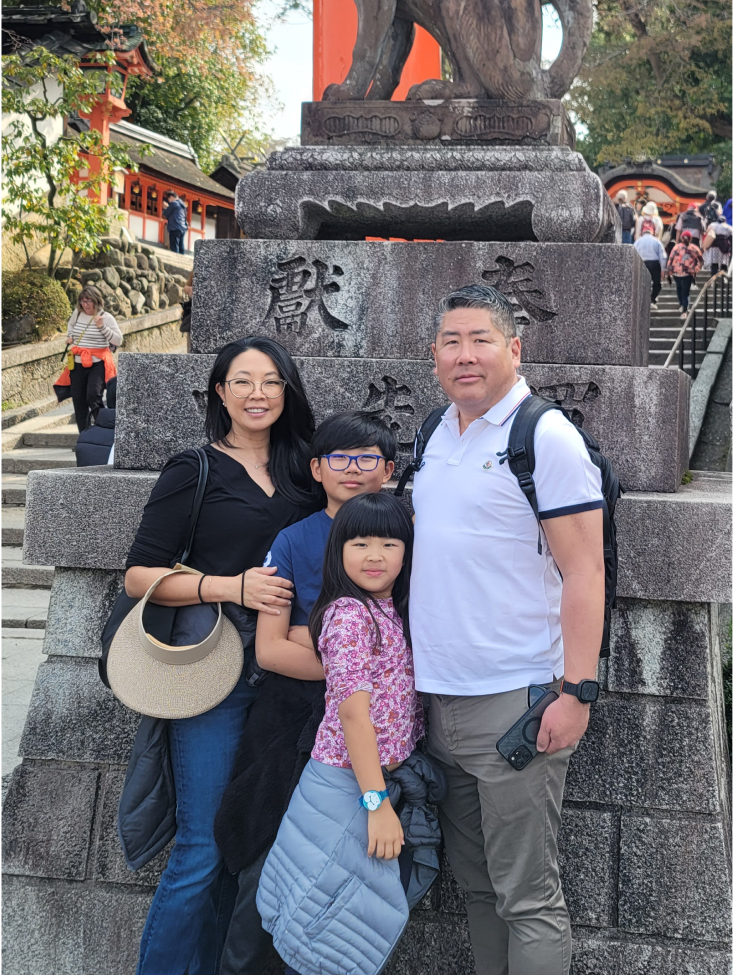 Family of four posing in front of Japanese monument