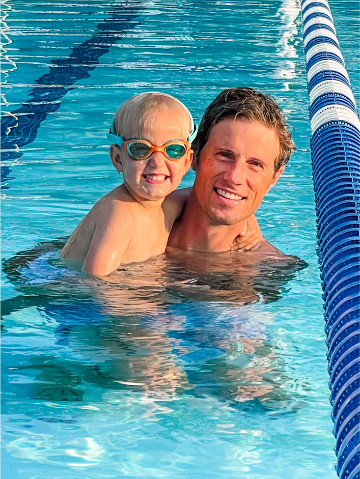 Father and son posing in a swimming pool