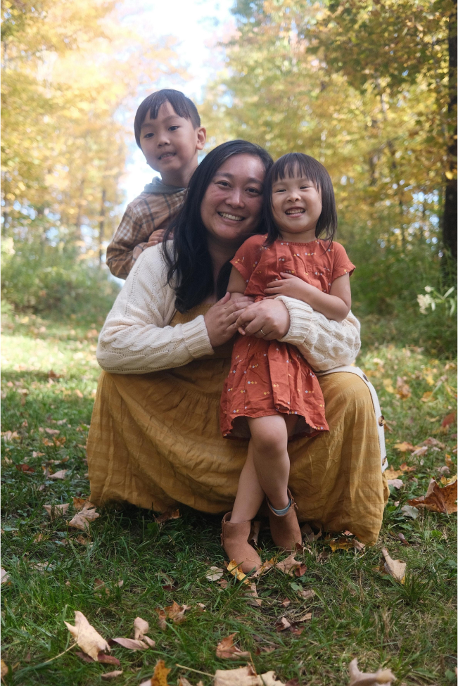 Parent and two children posing in scenic woods