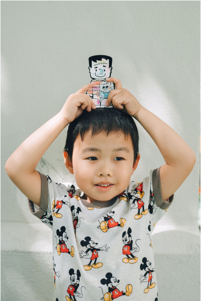 Child holding a toy on top of his head